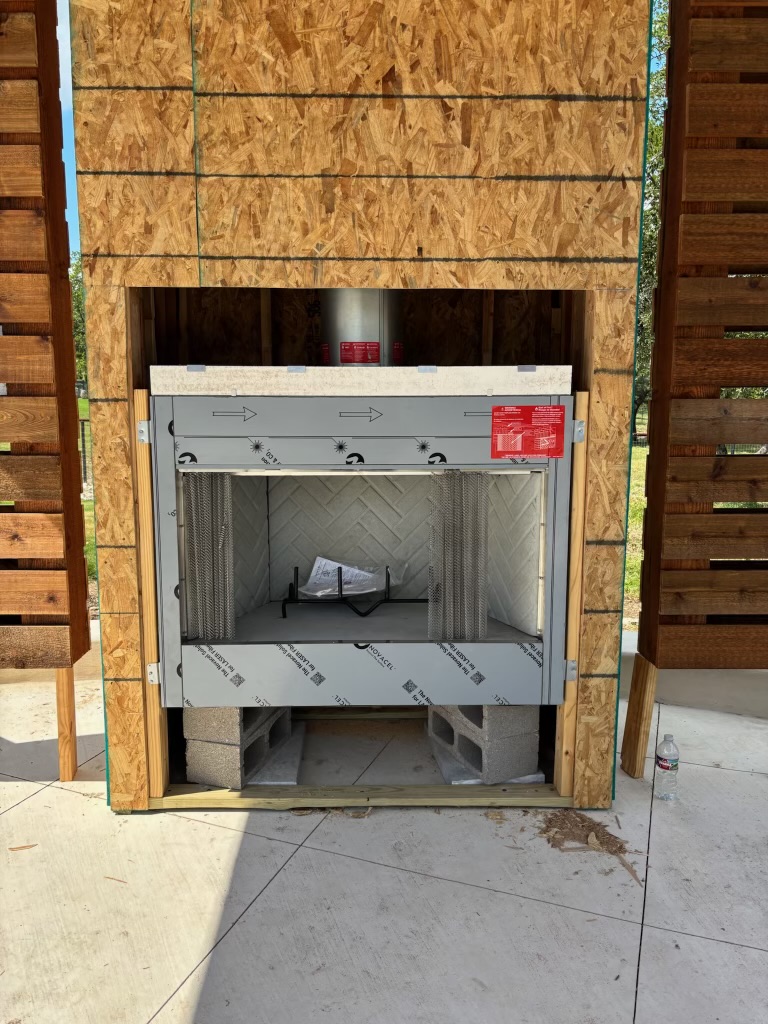 Outdoor fireplace firebox installed on a covered patio